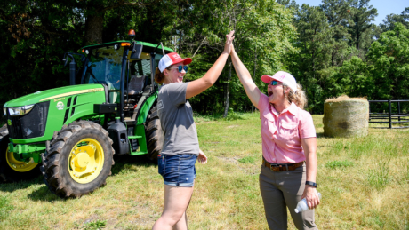 Two women high-five at the NC Women's Leadeship and Cattle Handling Workshop through NC State Extension