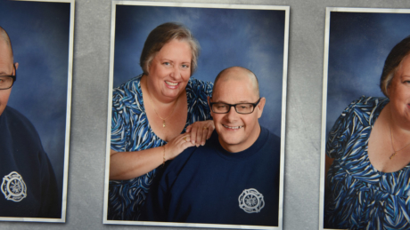 Portrait of David and Lisa Glosson; the couple is smiling happily against a blue background.