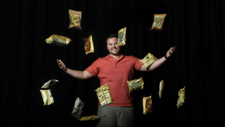 Carolina Kettle Chips founder Josh Monahan tosses bags of potato chips in the air like a happy juggler.