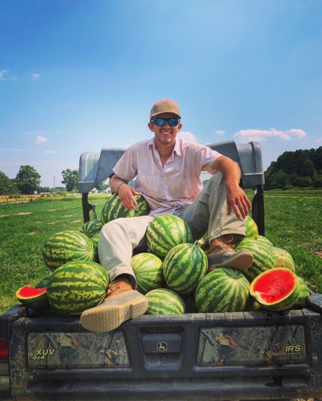 CALS student and food entrepreneur Collin Blalock sits on a truck full of watermelons.