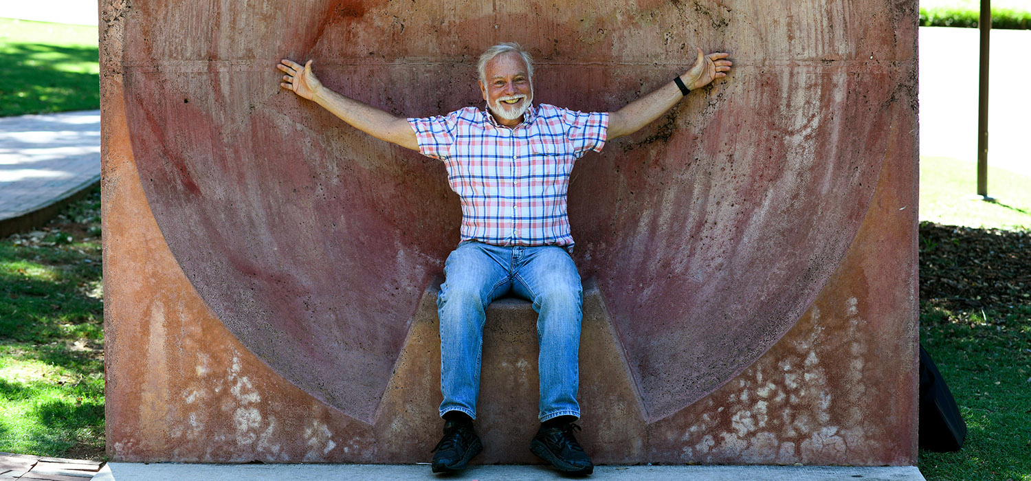 Genetic Engineer Fred Gould sits with arms outstretched in an echo device.