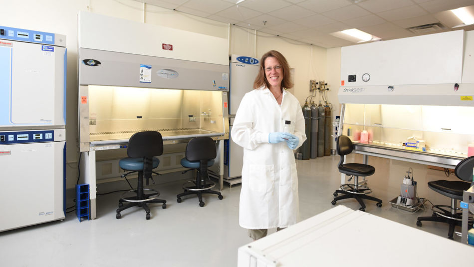 Biochem department head Melanie Simpson smiles in the middle of a clean renovated laboratory.